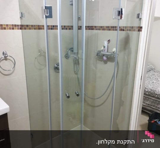 מקלחון זכוכית עם מדף וסבונים